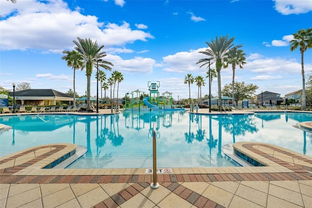 view of swimming pool featuring a playground and a water slide