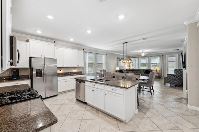 kitchen with sink, a center island with sink, ornamental molding, appliances with stainless steel finishes, and white cabinets