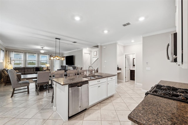 kitchen featuring sink, a center island with sink, light tile patterned floors, stainless steel appliances, and white cabinets