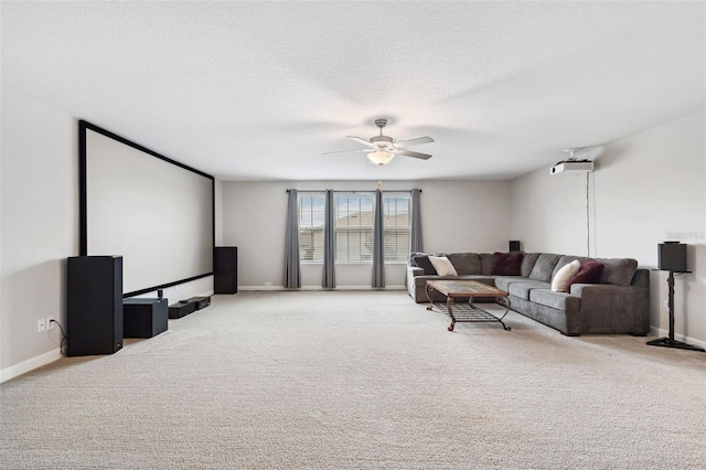 carpeted cinema room with a textured ceiling and ceiling fan