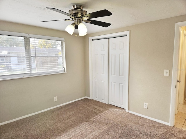 unfurnished bedroom with carpet floors, ceiling fan, and a closet