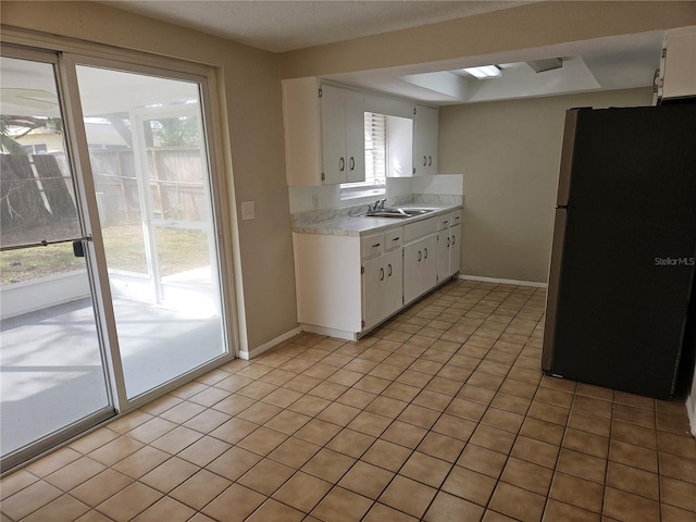 kitchen with white cabinetry, stainless steel refrigerator, and light tile patterned flooring