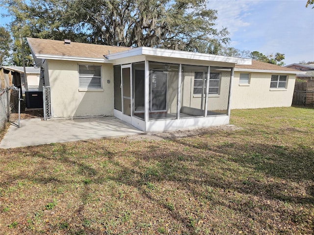 back of house featuring cooling unit, a patio, a sunroom, and a lawn