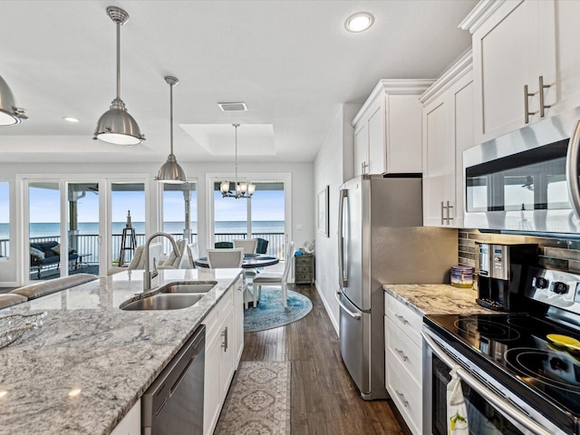 kitchen featuring sink, a water view, a raised ceiling, stainless steel appliances, and white cabinets