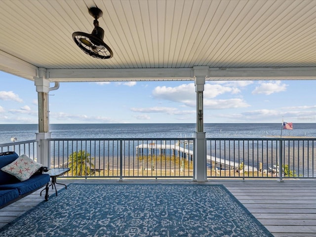 deck with a water view and ceiling fan