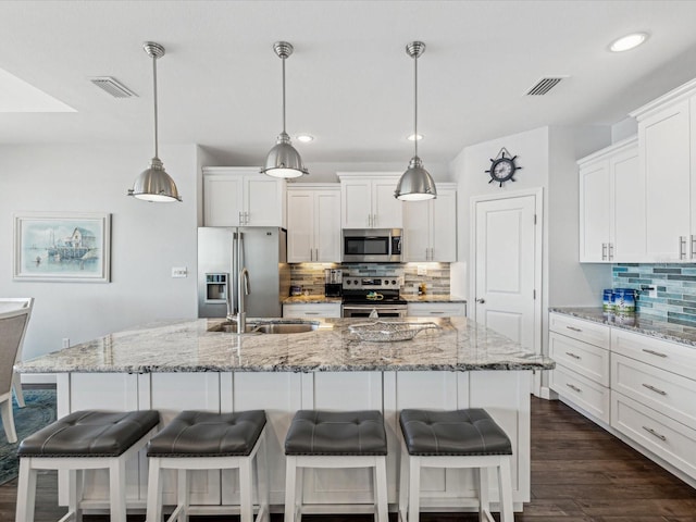 kitchen with a large island, hanging light fixtures, and appliances with stainless steel finishes