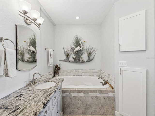 bathroom with vanity and tiled tub