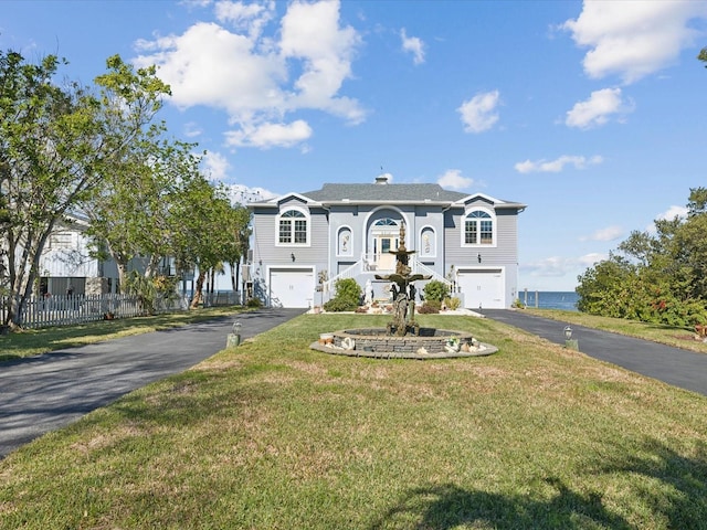 view of front of property featuring a water view, a garage, and a front yard