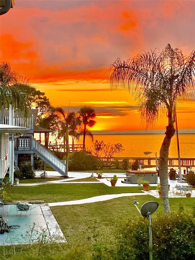 view of home's community featuring a patio, a water view, and a lawn