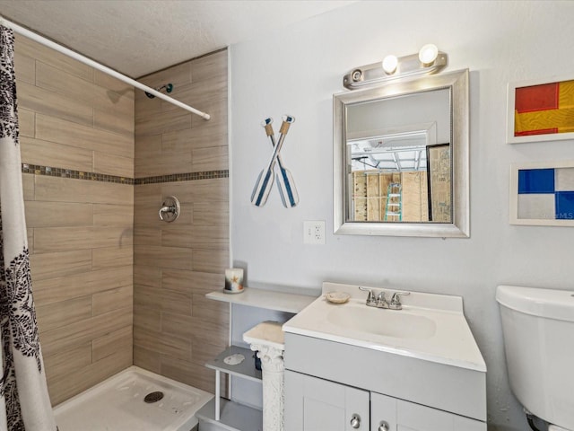 bathroom with a shower with curtain, vanity, a textured ceiling, and toilet