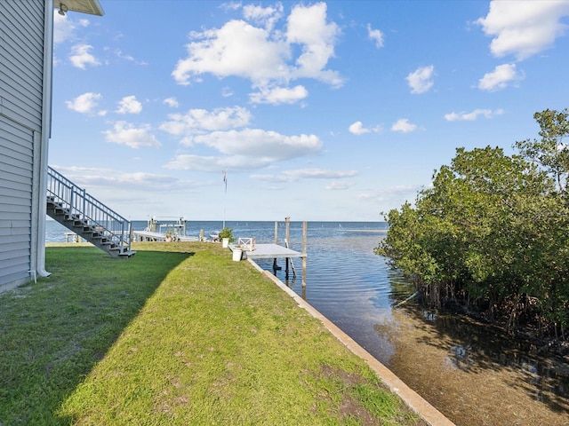 dock area with a water view and a lawn