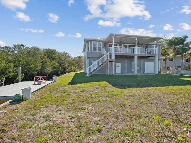 rear view of house with a wooden deck and a lawn