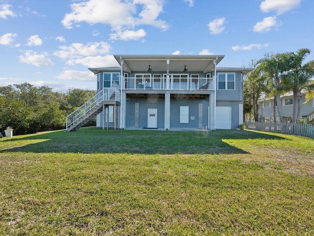 back of house featuring a wooden deck, a garage, a lawn, and ceiling fan