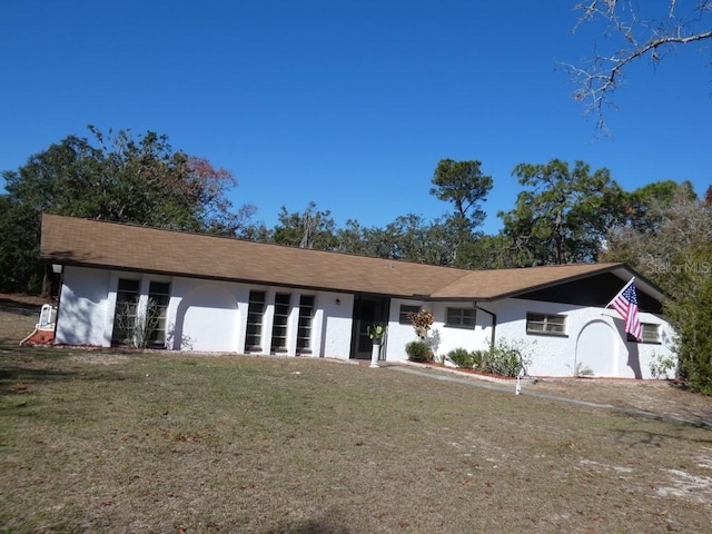 single story home featuring a front lawn