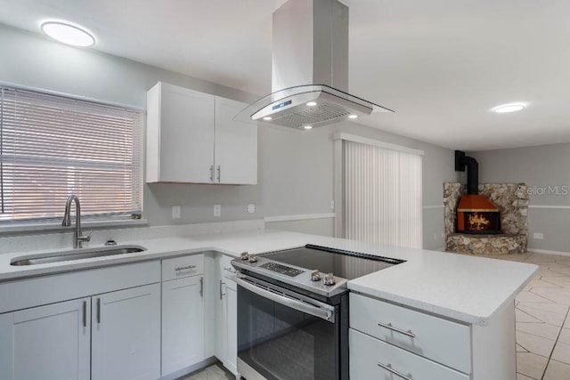 kitchen with white cabinetry, sink, stainless steel range with electric cooktop, island exhaust hood, and kitchen peninsula