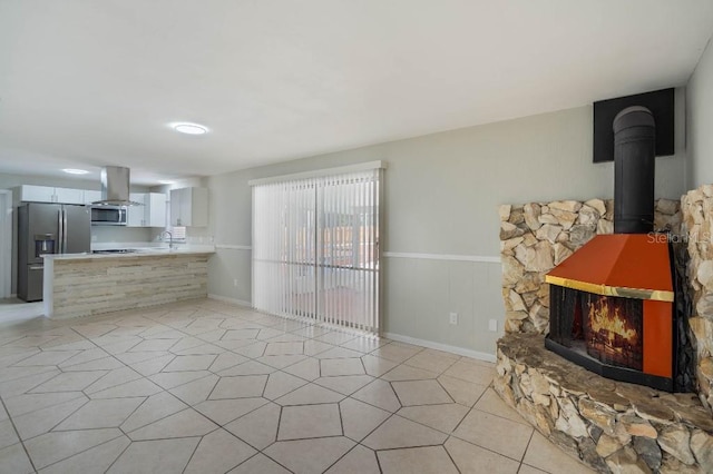 kitchen with sink, stainless steel appliances, white cabinets, island exhaust hood, and kitchen peninsula