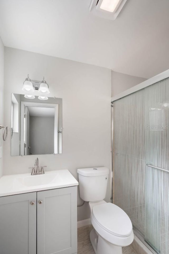 bathroom with vanity, walk in shower, and toilet