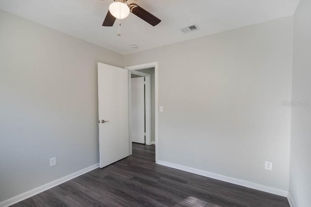 unfurnished room featuring dark wood-type flooring and ceiling fan