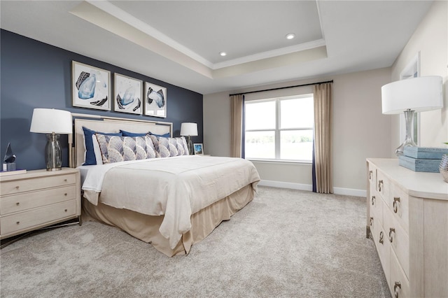 bedroom with light carpet and a tray ceiling