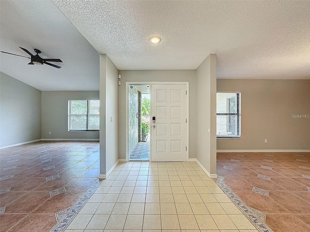 foyer with light tile patterned flooring, ceiling fan, and a textured ceiling