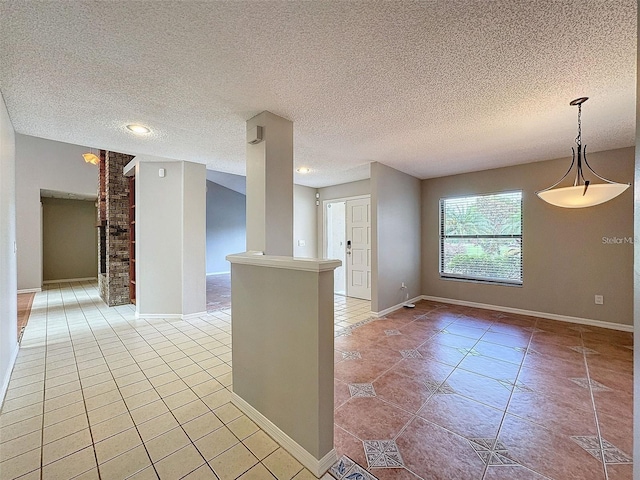 unfurnished room with light tile patterned flooring and a textured ceiling