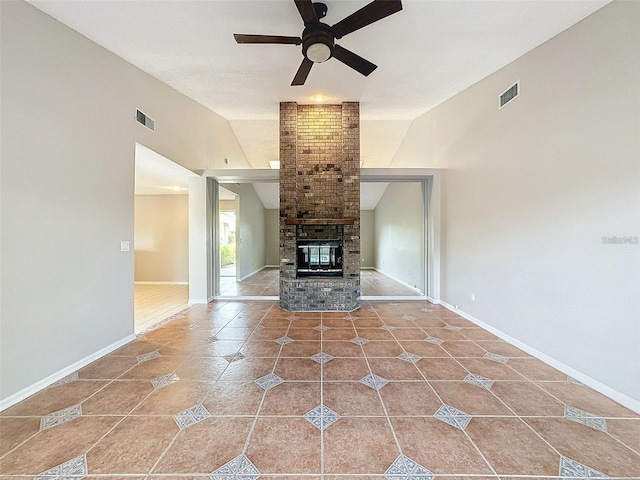 unfurnished living room with ceiling fan, a fireplace, tile patterned flooring, and vaulted ceiling