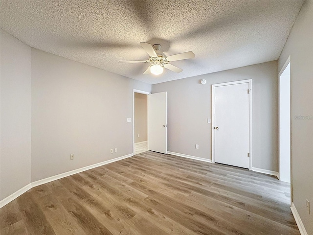 unfurnished room featuring ceiling fan, wood-type flooring, and a textured ceiling