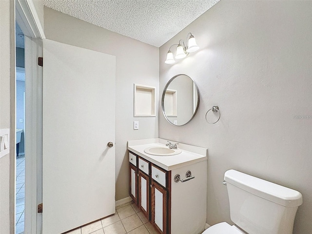 bathroom with tile patterned floors, toilet, a textured ceiling, and vanity