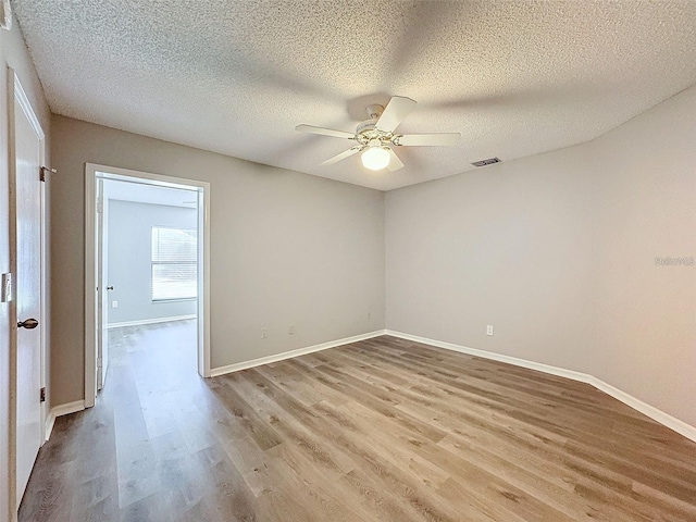 unfurnished room featuring ceiling fan, a textured ceiling, and light wood-type flooring