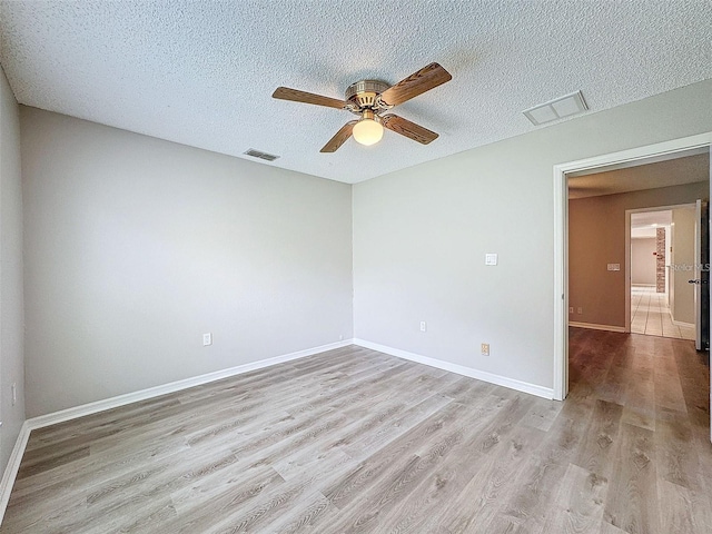 spare room featuring ceiling fan, a textured ceiling, and light wood-type flooring