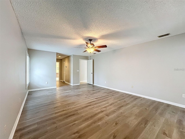 empty room featuring hardwood / wood-style floors, a textured ceiling, and ceiling fan