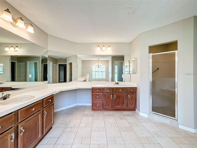 bathroom with vanity, tile patterned floors, an enclosed shower, and a textured ceiling