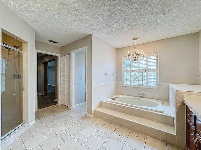 bathroom featuring separate shower and tub, vanity, a textured ceiling, tile patterned floors, and a chandelier