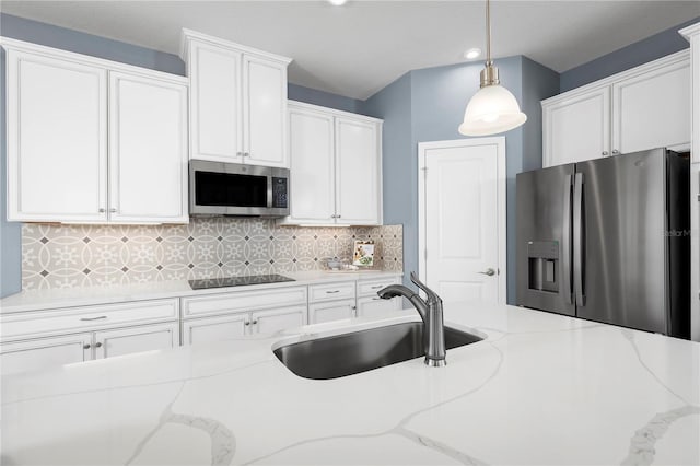 kitchen featuring white cabinetry, stainless steel appliances, sink, and hanging light fixtures