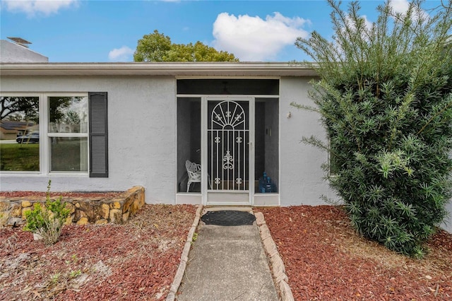 view of exterior entry with stucco siding