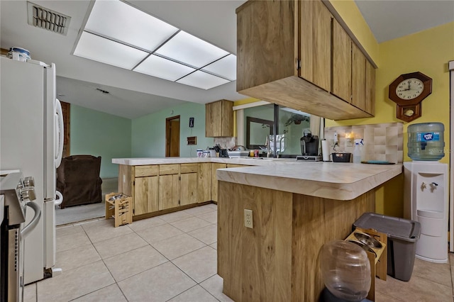 kitchen featuring visible vents, light countertops, a peninsula, stainless steel electric range, and light tile patterned flooring