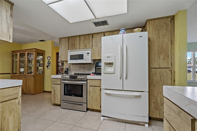 kitchen featuring light tile patterned floors, visible vents, white appliances, and light countertops