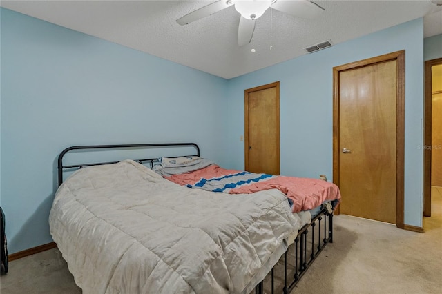 carpeted bedroom featuring visible vents, baseboards, a textured ceiling, and ceiling fan