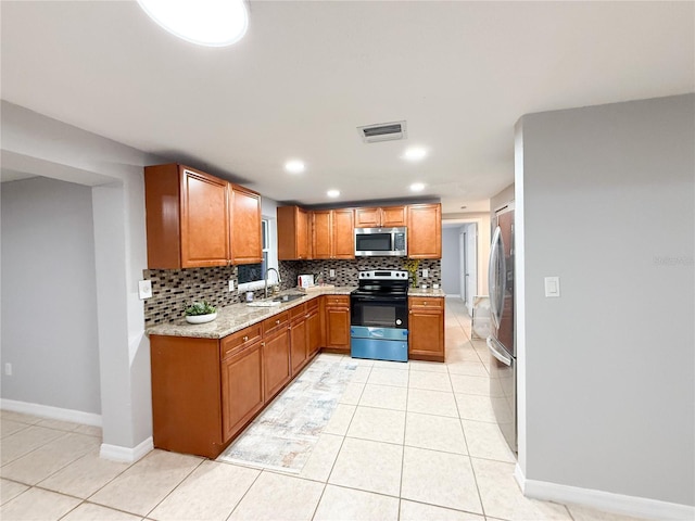 kitchen with light tile patterned floors, appliances with stainless steel finishes, sink, and backsplash