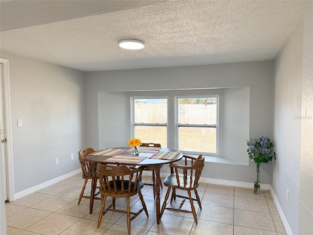 dining room with light tile patterned flooring and a textured ceiling