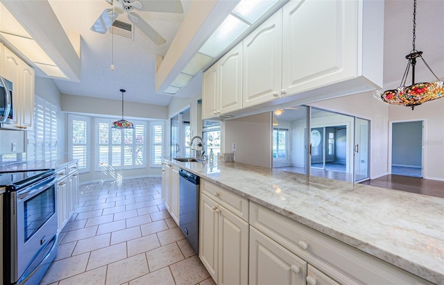 kitchen featuring light tile patterned flooring, sink, light stone counters, hanging light fixtures, and stainless steel appliances