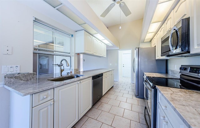 kitchen with sink, white cabinetry, light tile patterned floors, appliances with stainless steel finishes, and ceiling fan