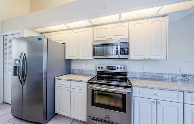 kitchen featuring white cabinetry, appliances with stainless steel finishes, and light tile patterned flooring