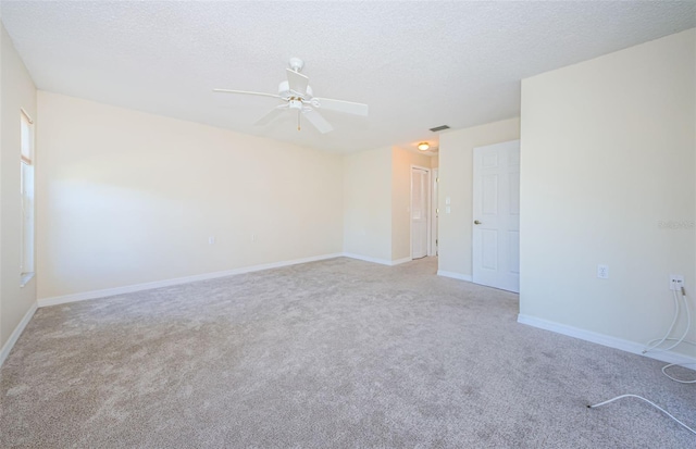 carpeted spare room with ceiling fan and a textured ceiling