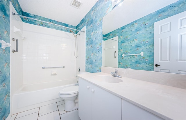 full bathroom featuring tile patterned flooring, vanity, a textured ceiling, toilet, and tiled shower / bath