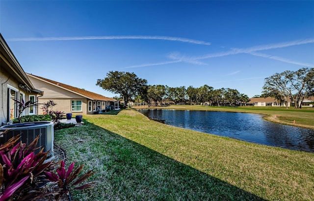 view of yard with central AC and a water view