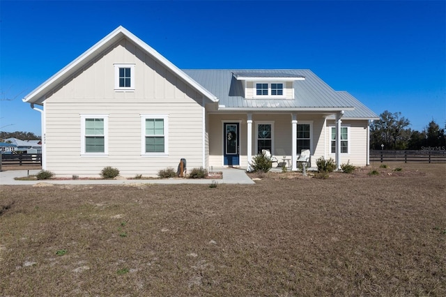 modern farmhouse with a front yard and covered porch