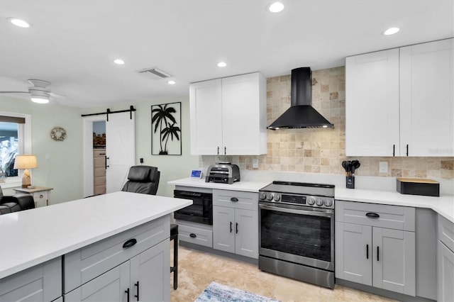 14124 Kulig Ct, Hudson, FL 34667 - kitchen with a barn door, visible vents, stainless steel electric range oven, gray cabinetry, and wall chimney range hood
