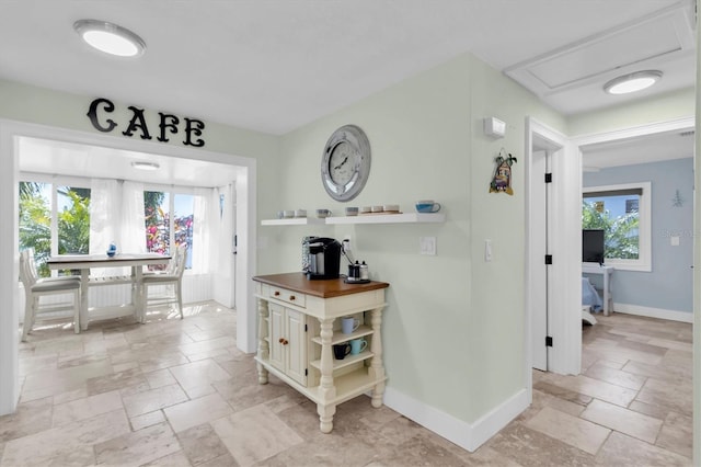 14124 Kulig Ct, Hudson, FL 34667 - hallway featuring a wealth of natural light, baseboards, and stone tile flooring