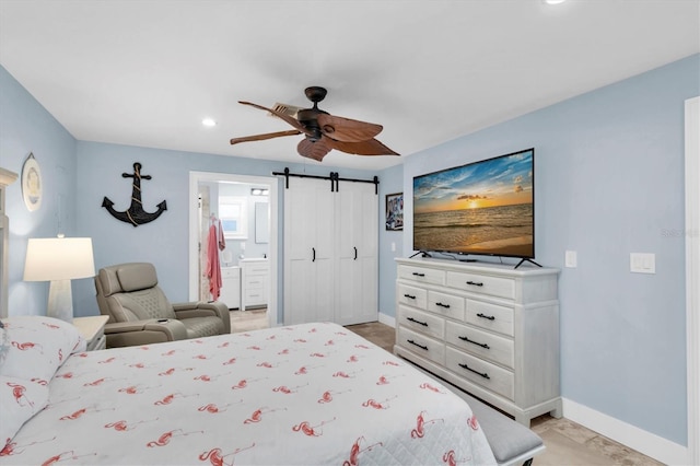 14124 Kulig Ct, Hudson, FL 34667 - bedroom with ensuite bath, a barn door, baseboards, and a ceiling fan